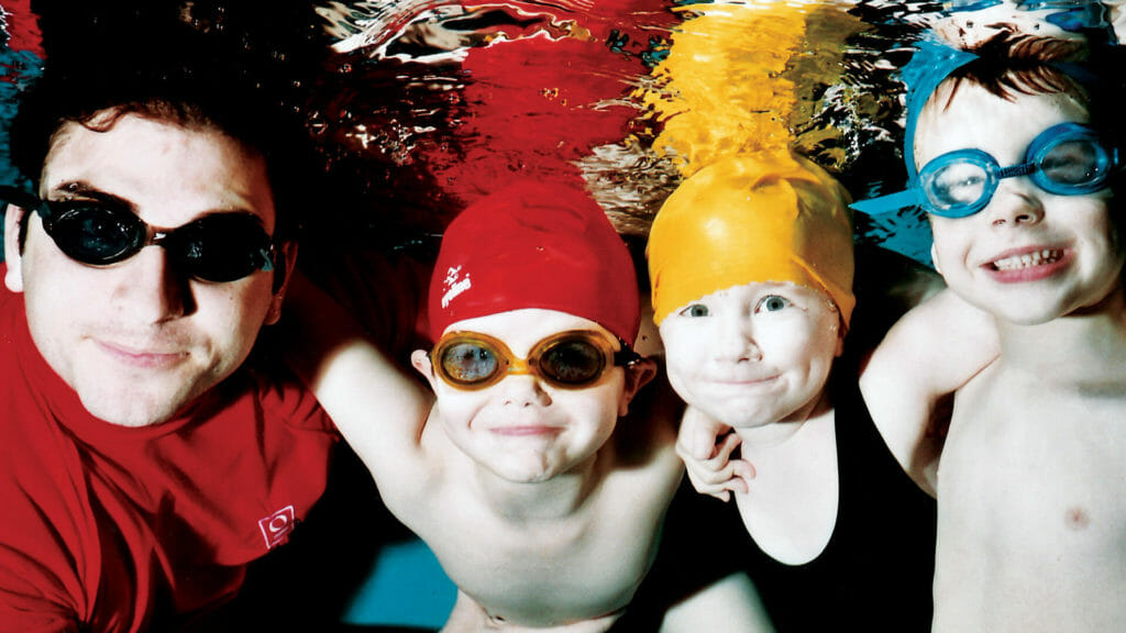 three children learning to swim with swimway