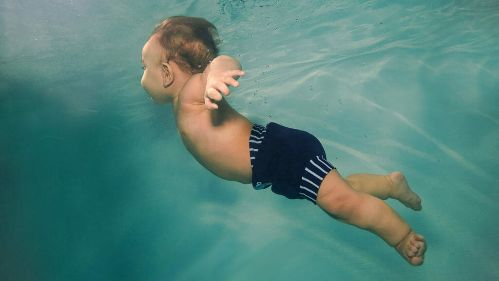 child swimming with a happy nappy