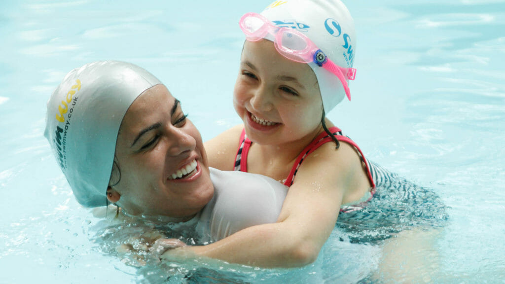 a swimway subsitute teacher teaching a young girl to swim