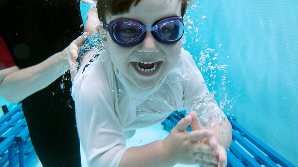 child learning to swim with swimway