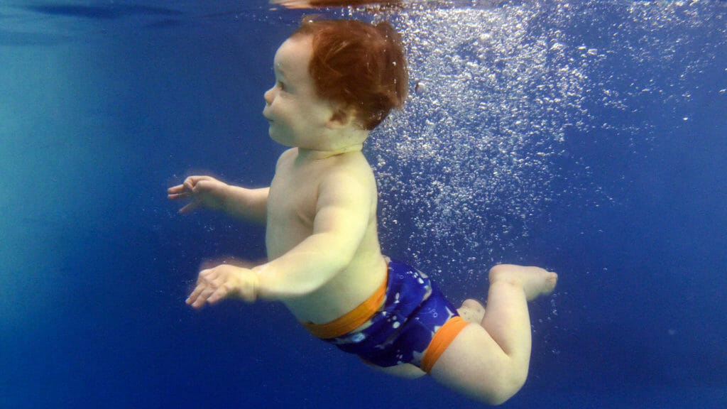 young child submerging under the water