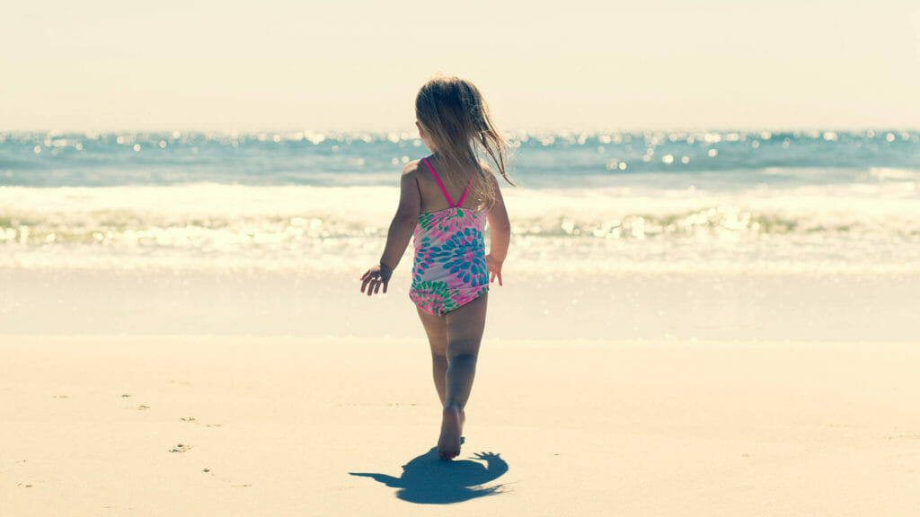 young child running on a beach